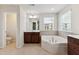 Bright bathroom features a large soaking tub, a walk-in shower, and vanity with dark-colored cabinets at 205 Begen St, Morrisville, NC 27560