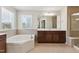 Bathroom with a large soaking tub, walk-in shower, and a vanity with a window at 205 Begen St, Morrisville, NC 27560