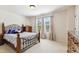 Bedroom with a wooden bed frame, two windows with curtains, and neutral colored walls at 205 Begen St, Morrisville, NC 27560