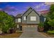 Two-story home showcasing a two-car garage, neutral siding, and a well-maintained lawn with mature landscaping at 205 Begen St, Morrisville, NC 27560
