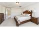 A bright main bedroom with decorative, dark wood furnishings and neutral-colored walls and carpet at 205 Begen St, Morrisville, NC 27560
