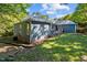 Home exterior featuring wood deck and a lush green lawn on a sunny day at 2123 Fountain Ridge Rd, Chapel Hill, NC 27517