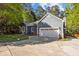 Charming blue house with an attached two-car garage and a long driveway surrounded by lush greenery at 2123 Fountain Ridge Rd, Chapel Hill, NC 27517