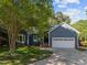Charming blue home featuring a manicured lawn, mature trees, and a two-car garage at 2123 Fountain Ridge Rd, Chapel Hill, NC 27517