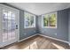 Bright sunroom with wood floors, shiplap walls, and glass pane door and windows overlooking a serene outdoor setting at 2123 Fountain Ridge Rd, Chapel Hill, NC 27517