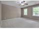 Primary bedroom features neutral carpet, a ceiling fan, and two windows for natural light at 225 Bay Dr, Cary, NC 27511