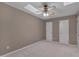 Neutral bedroom with a tray ceiling, ceiling fan and two doors at 225 Bay Dr, Cary, NC 27511