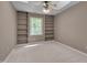 Bedroom with a tray ceiling, ceiling fan and built-in shelves on either side of the window at 225 Bay Dr, Cary, NC 27511