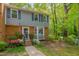Inviting exterior view showcasing a blue townhouse with brick, blue shutters, flowers, and an American flag at 225 Bay Dr, Cary, NC 27511
