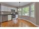 Updated eat-in kitchen with stainless steel appliances, white cabinetry, granite counters and hardwood floors at 225 Bay Dr, Cary, NC 27511