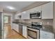 Well-lit kitchen with stainless steel appliances, granite countertops and sleek white cabinets at 225 Bay Dr, Cary, NC 27511