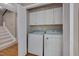 Laundry room with washer, dryer, shelving, and white cabinets in a closet with bi-fold doors at 225 Bay Dr, Cary, NC 27511