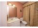 Standard bathroom design with white cabinets, faucet and toilet with peach painted walls and striped shower curtain at 2318 Carriage Oaks Dr, Raleigh, NC 27614