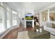 Bright living room featuring hardwood floors, a fireplace with TV, and elegant trim details at 2318 Carriage Oaks Dr, Raleigh, NC 27614