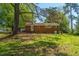 View of backyard with a brick house, lush trees, and green grass at 2500 Courtland Dr, Sanford, NC 27330