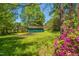 Backyard with a shed surrounded by blooming flowers and lush greenery at 2500 Courtland Dr, Sanford, NC 27330