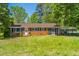 Quaint brick home with a screened porch and covered parking surrounded by mature trees at 2500 Courtland Dr, Sanford, NC 27330