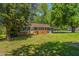 Charming brick home with well-maintained lawn, complemented by mature trees and a screened in patio at 2500 Courtland Dr, Sanford, NC 27330
