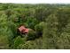 An aerial shot showcases a home with a red roof, beautifully situated among dense, green trees at 2917 Ericka Dr, Hillsborough, NC 27278