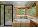 Bright bathroom features an oval soaking tub with tile surround and separate shower with glass door at 2917 Ericka Dr, Hillsborough, NC 27278