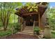 Charming covered front porch with wooden details nestled among lush trees at 2917 Ericka Dr, Hillsborough, NC 27278