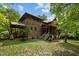 Spacious wooded home exterior featuring a back porch, stairs, and mature landscaping at 2917 Ericka Dr, Hillsborough, NC 27278