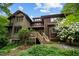 Inviting multi-level home with a wooden deck surrounded by lush greenery and vibrant flowers at 2917 Ericka Dr, Hillsborough, NC 27278