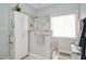 Modern bathroom with glass-enclosed shower, white cabinets, and bench seating with natural light at 304 Parkridge Dr, Clayton, NC 27527