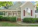 Inviting home exterior with a cozy front porch, red shutters, and manicured landscaping at 304 Parkridge Dr, Clayton, NC 27527