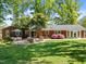 Brick home featuring a patio, fire pit, and lush green lawn at 305 Clarendon Cres, Raleigh, NC 27610