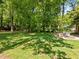 Large green backyard featuring a patio, grill, seating area, and shade trees at 305 Clarendon Cres, Raleigh, NC 27610