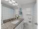 Bright bathroom features granite countertop, white cabinets, and neutral hexagon tile flooring at 305 Clarendon Cres, Raleigh, NC 27610