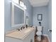 Stylish half bathroom featuring neutral walls, a decorative mirror, and modern fixtures at 305 Clarendon Cres, Raleigh, NC 27610