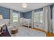 This bedroom features blue wallpaper, wood floors, and curtains framing a window overlooking the exterior at 305 Clarendon Cres, Raleigh, NC 27610