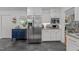 Modern kitchen features stainless steel appliances, white cabinets, and a dark tiled floor at 305 Clarendon Cres, Raleigh, NC 27610