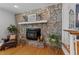 The cozy living room is enhanced by a stone fireplace, hardwood floors, and bright natural light at 305 Clarendon Cres, Raleigh, NC 27610