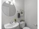 Neat half bathroom featuring a modern sink, round mirror, and contemporary decor at 3148 Rapid Falls Rd, Cary, NC 27519