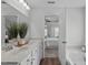 Bright bathroom with dual sinks, framed mirror, and an open doorway to the main bedroom and soaking tub at 3148 Rapid Falls Rd, Cary, NC 27519