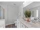 Well-lit bathroom featuring a dual sink vanity with white cabinets, marble countertops, and decorative plants and fresh white towels at 3148 Rapid Falls Rd, Cary, NC 27519