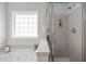 Elegant bathroom featuring a luxurious soaking tub, separate glass-enclosed shower, and a frosted window at 3148 Rapid Falls Rd, Cary, NC 27519