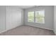 Neutral carpeted bedroom with a double door closet and natural light from the two windows at 3148 Rapid Falls Rd, Cary, NC 27519