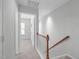 Upstairs hallway with carpeted floors and wood and white banister leading to an upstairs bedroom at 3148 Rapid Falls Rd, Cary, NC 27519