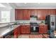 Kitchen features cherry cabinets, stainless steel appliances, and solid surface countertops at 3148 Rapid Falls Rd, Cary, NC 27519