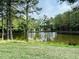 Scenic pond view surrounded by lush trees and greenery at 3148 Rapid Falls Rd, Cary, NC 27519