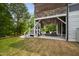 Spacious covered porch with stone accents, outdoor seating, and steps to the lush backyard at 3215 Bellamy Ridge Dr, Apex, NC 27523