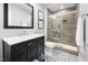 This renovated bathroom includes a vanity with marble countertop, patterned tile floor, and walk-in shower with glass doors at 3215 Bellamy Ridge Dr, Apex, NC 27523