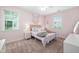 Light-filled bedroom features pale pink walls and coordinating decor and window treatments at 3215 Bellamy Ridge Dr, Apex, NC 27523