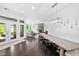 Bright open-concept dining room with a light wood table, stylish black chairs, and dark wood floors at 3215 Bellamy Ridge Dr, Apex, NC 27523