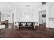 Dining room with dark wood floors and an elegant light fixture above a wooden table with stylish chairs at 3215 Bellamy Ridge Dr, Apex, NC 27523