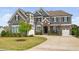 Beautiful two-story home featuring stone accents, lush lawn, and a long concrete driveway at 3215 Bellamy Ridge Dr, Apex, NC 27523